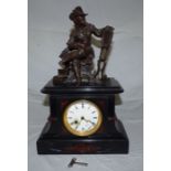 A French black marble and red inlay mantel clock, surmounted by a patinated bronze figure of a