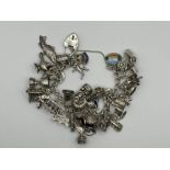 1961 hallmarked sterling silver charm bracelet holding 33 charms - gross weight 90.2g (1)