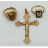 A 9ct gold crucifix; with a tigers eye ring (size Q); and a black gem set monogram ring (size N).