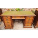 An early 20th century oak pedestal desk, slight oversailing top fitted with green leather inlay