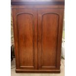 A Victorian mahogany wardrobe, circa 1860, curved moulded pediment above two panel arch moulded