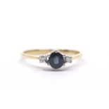 A sapphire and diamond ring, claw set oval cut sapphire and two small diamonds to the shoulders