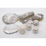A group of early 20th Century dressing table silver to include: two brushes, a table mirror, two