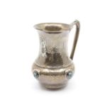 An Arts & Crafts silver large mug in the manner of Liberty, the baluster hammered body with flared
