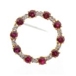 A ruby and diamond 18ct gold brooch, open circular form set with alternate round cut and brilliant