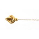 A gold stick pin, knot terminal, width approx 16mm, unmarked assessed as 9ct gold, weight approx