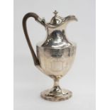 A George III Neo-Classical silver claret jug, the facetted body bright cut engraved with swags and