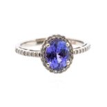 A tanzanite and diamond platinum ring, comprising an oval claw set tanzanite, weighting approx 1.