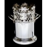 An Edwardian silver two handled wine bottle holder, the upper section with scrolls, openwork