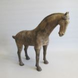 A Tang Dynasty unglazed model of a Horse, standing four square with its head slightly lowered