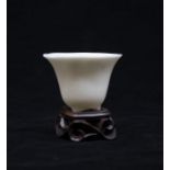 A Qing Dynasty Dehua Tripod Libation Cup. The rounded sides rising to an everted rim, one side
