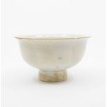 A Song Dynasty Qingbai foliate footed bowl the rounded sides rising from a tall, tapered foot to