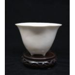 A large Dehua Qing Dynasty Blanc de Chine Libation Cup in the form of a Lotus flower, raised on