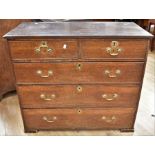 A George III oak chest of two above three drawers on block feet and with brass swing handles