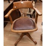 A 1930s oak swivel desk chair on splayed legs and castors