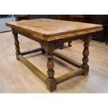 A late 20th Century rustic style oak dining table with extending leaves, 150cm long x 80cm wide