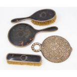A silver and tortoiseshell  dressing table set comprising hand mirror, hair brush and clothes brush,