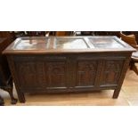 A large oak 17th Century carved coffer with four carved front panels on block legs