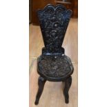 A 19th Century oak folk-carved hall chair with foliage detail, heart back support, carved front legs