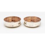A pair of Modern plain circular silver bottle / wine coasters, with central silver circular motif,