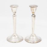 A pair of Modern Irish silver candlesticks, plain urn shaped sockets above tapering stems on