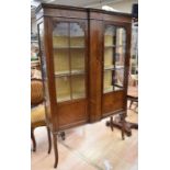 An Edwardian mahogany two door display cabinet having two internal shelves, cross-grain panelling on