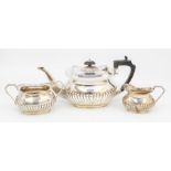 A George V silver three piece tea service, comprising teapot, milk jug and sugar bowl, gadroon lower