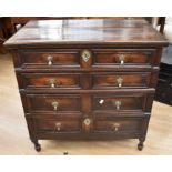 An early 18th Century oak chest of four drawers with panelled fronts and drop handles