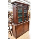 A Victorian mahogany glazed bookcase cupboard with two internal shelves behind glazed doors above