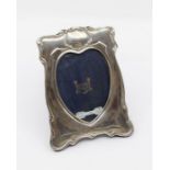 An Art Nouveau style silver mirror, shaped border with heart shaped inset, easel velvet backed,
