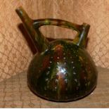 A Linthorpe pottery water jug designed by Christopher Dresser with double spout, the domed body with