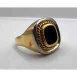 A yellow metal signet ring stamped 750 with CM makers mark. Set with black onyx. Gross weight 19.7