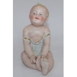 A late 19th century bisque German Piano Baby  , 17cm high