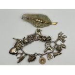 A white metal charm bracelet, with 19 charms on (one of which is stamped silver) (gross weight