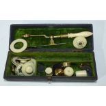 A boxed scientific instrument with a brass body and bone handle .