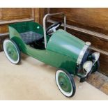 A Child's Green Metal 1930's Style Pedal Car, modern, with plastic steering wheel, moulded seat,