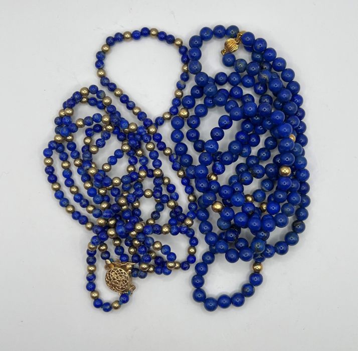 A 14 k gold clasp lapis lazuli and gilt metal bead necklace and another lapis lazuli necklace with