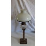 An oil lamp , on Corinthian column silver plated base, having opaline shade and clear chimney,