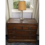 A George III provincial oak chest of drawers, with later adapted top and lopers, over two short and