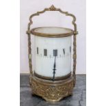 A French opaque milk glass and brass cylinder night clock, the case cast with birds and foliage,