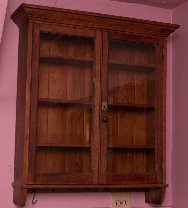 An Edwardian oak glazed wall cabinet, with brass art nouveau lockplate inscribed “Kingfisher Ltd,