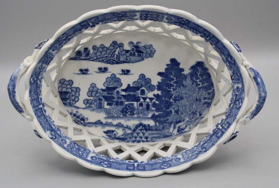 An early 19th century English pottery twin handled pierced basket, Chinoiserie printed decoration in