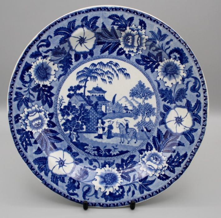 An early 19th century blue and white pottery plate, printed underglaze with a boy on a zebra in an