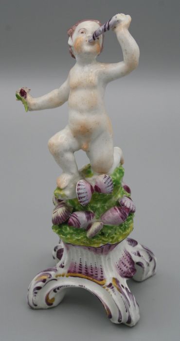 An 18th century Bow porcelain figure of a minor sea God, blowing a conch, on a puce shell applied