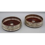 MC Hersey, a pair of silver 12.5cm diameter bottle coasters, each with turned wood base, stamped .