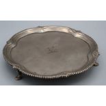 A George II Irish silver waiter, the lobed shell decorated beaded rim around an engraved crest, on