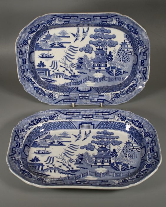 A pair of mid 19th century blue and white pottery meat platters, each printed with Willow pattern,