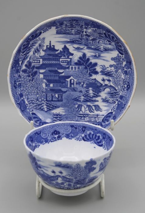 A Spode bone china tea bowl and saucer with indented rims, transfer decorated underglaze with Willow