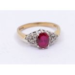 A synthetic ruby and diamond dress ring, comprising a central oval cut synthetic ruby claw with
