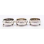 A set of three Victorian silver circular salts, the sides engraved with fern leaves, on three ball